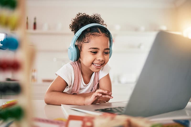 Happy child learning second language on laptop